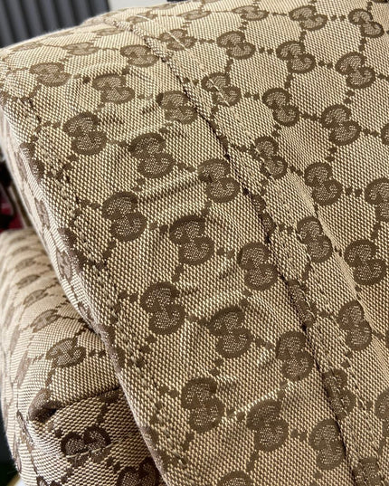 Close-up of a patterned fabric with a visible brand logo in the background